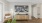 a living room with a large painting and a chair