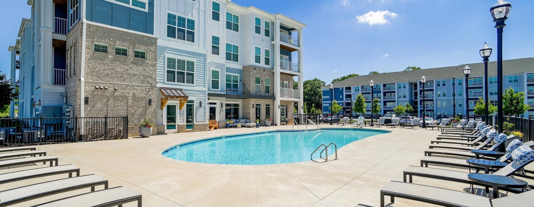 a swimming pool in a courtyard with lounge chairs